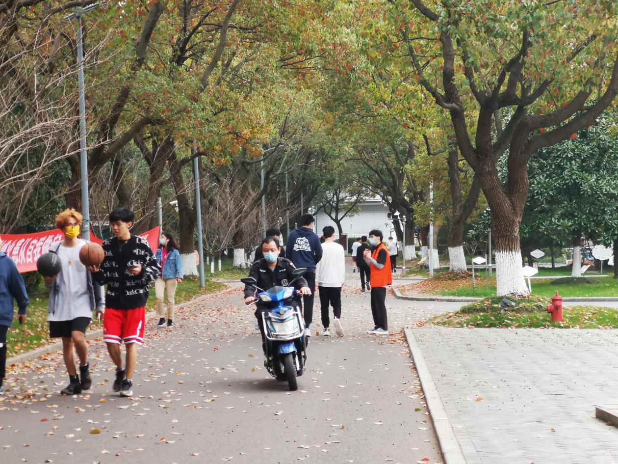 入党积极分子田应飞在学生宿舍园区引导大家正确佩戴口罩